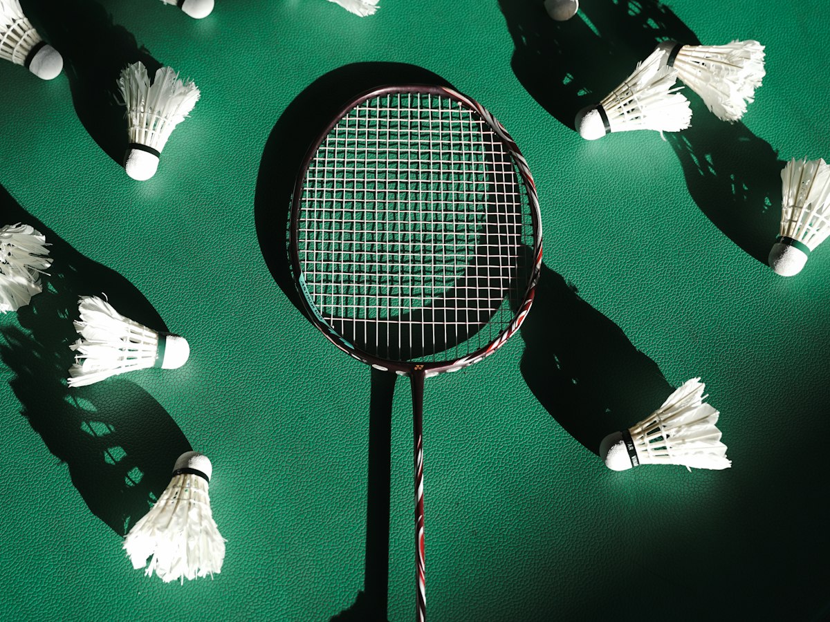Badminton racket and shuttlecocks on a green court
