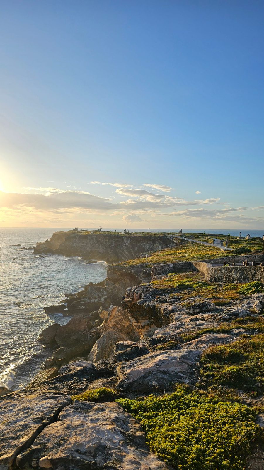 Rocky coastline and cliff path glowing in the late afternoon sun